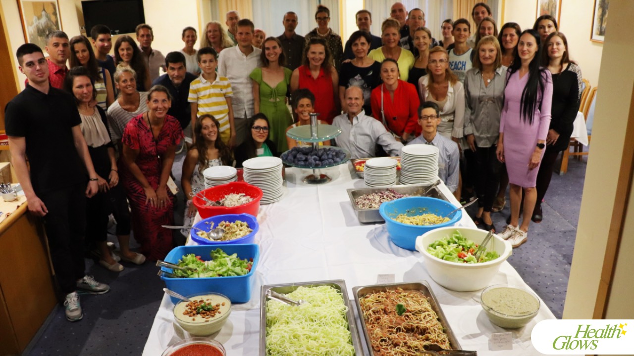 Group photo of the participants and organisers of the 'Serbian Fruit Festival' 2023 standing in the dining room of the 'Prezident' Hotel in Palic, Serbia. This picture shows happy festival guests standing by an abundantly laid dining table full of fresh plant-based food. 'Serbian Fruit Festival' - a 4-day event at which you get the opportunity to eat a raw vegan diet, exercise and get professional education on a raw diet and natural health.