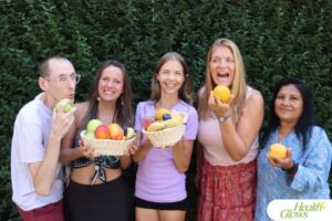Five participants of the 'Serbian Fruit Festival' 2024 smiling stand in a row holding fruits.