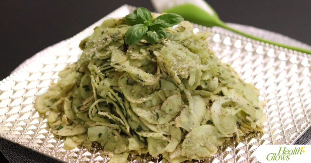 Raw vegan fusilli al pesto pasta on a plate.