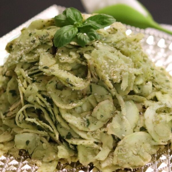 Raw vegan fusilli al pesto pasta on a plate.