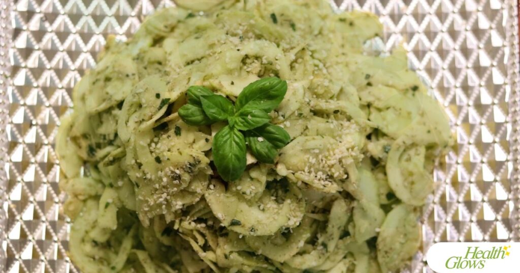 Raw vegan fusilli al pesto pasta on a plate pictured from above.
