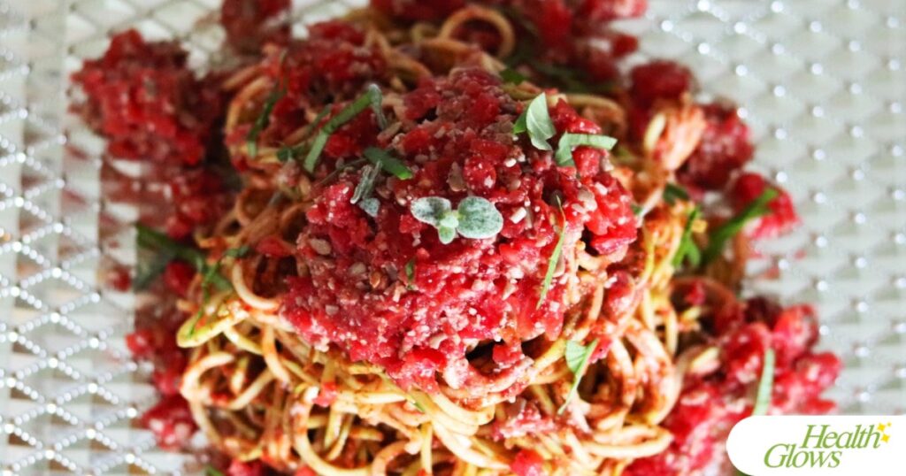 Raw vegan spaghetti marinara pasta on a plate pictured from above.