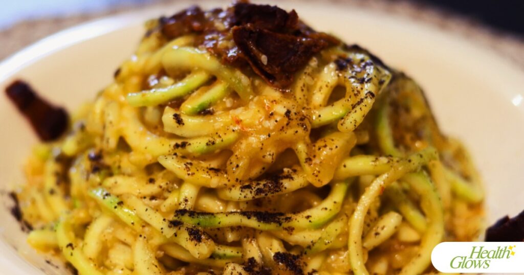 Raw vegan spaghettoni carbonara pasta on a plate.