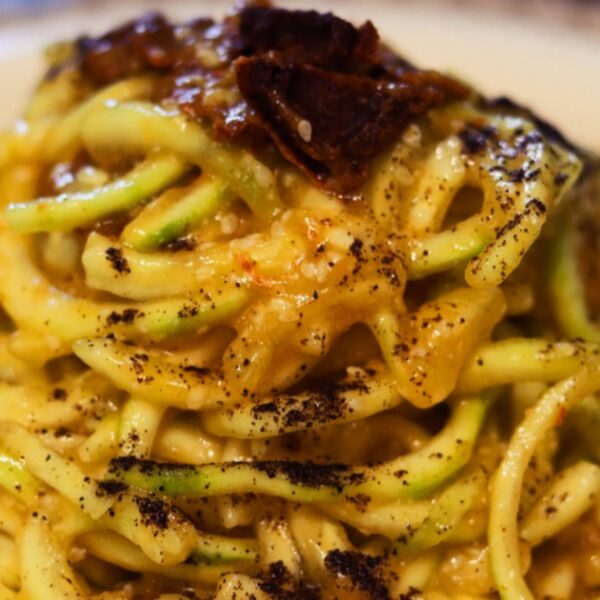 Raw vegan spaghettoni carbonara pasta on a plate.