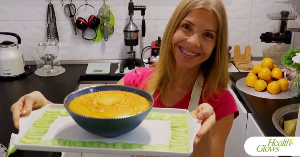 Marina from Health Glows is holding a white tray with a bowl of persimmon pudding and thin cucumber slices.