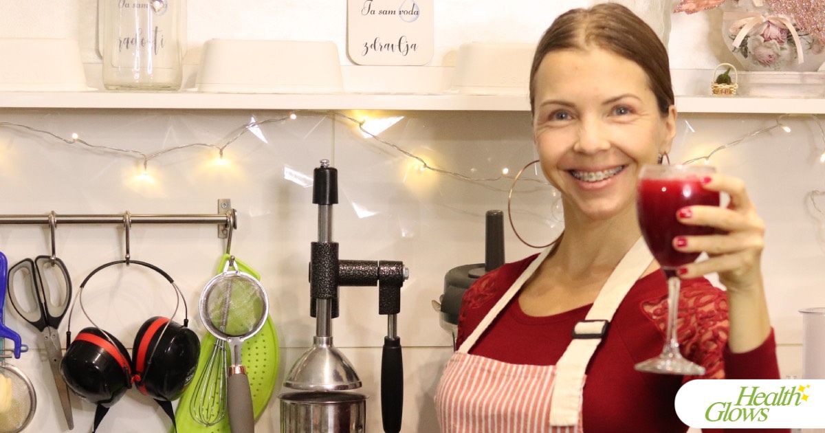 Marina from Health Glows toasting with a wine glass filled with pomegranate juice.