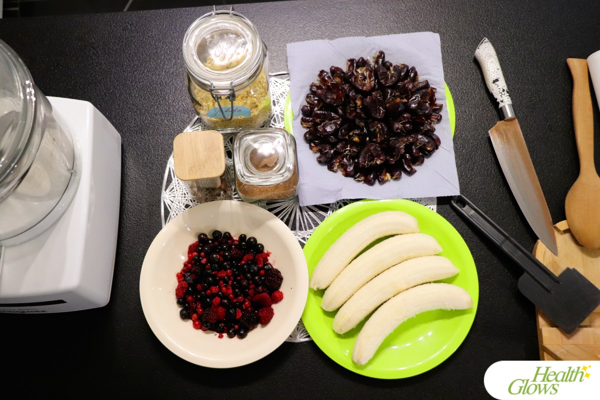 Ingredients for making a raw vegan banana-berry cake laid out on the kitchen counter. The picture was taken from above.