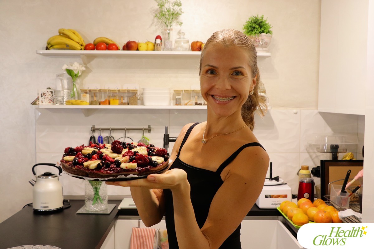 Marina from Health Glows holding a raw vegan banana-berry cake.